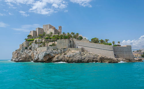 Castle by sea against sky