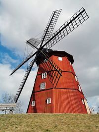 Traditional windmill on field against sky