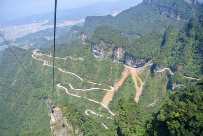 Winding road to tienmen mountain in zhangjiajie, china, compare to straight line of cable cars