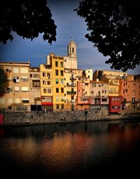 River by buildings against sky