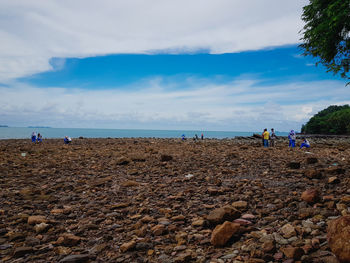 People on beach against sky