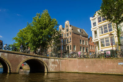 Bridge over river in city against clear sky