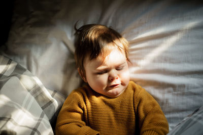 Directly above shot of cute baby boy lying on bed at home