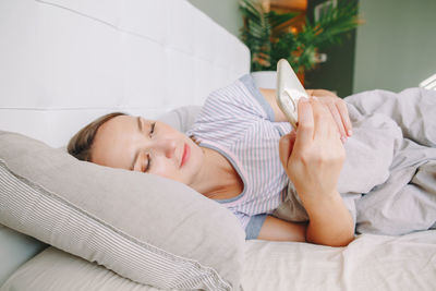 Midsection of woman relaxing on bed at home