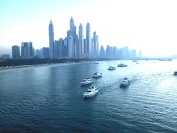 View of boats in sea against buildings in city