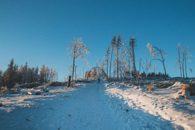 Scenic view of snowy field against clear blue sky