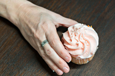 Shot of handing holding a fresh cupcake