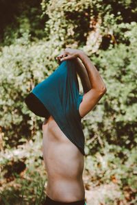 Rear view of woman standing against trees
