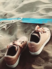 Close-up of shoes on sand