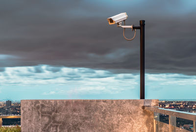 Street light against wall in city against sky