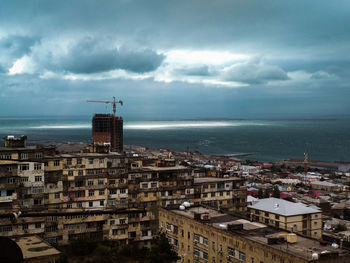 High angle view of townscape by sea against sky