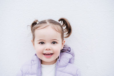 Portrait of cute girl against wall