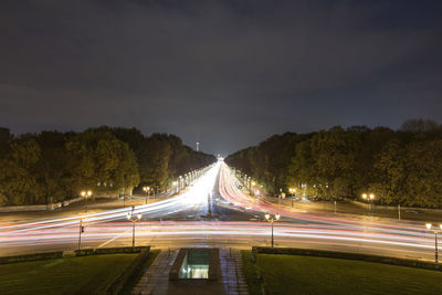 Light trails on road against sky at night