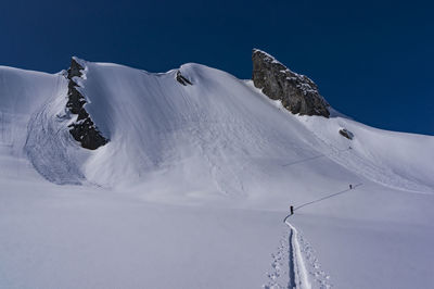 Scenic view of snow covered mountains against clear sky