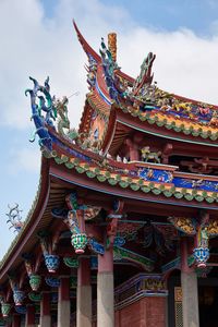 Low angle view of temple and building against sky