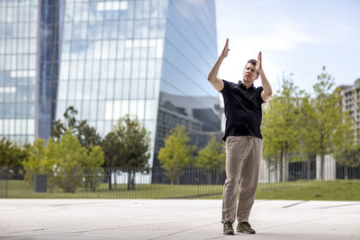 Full length of mature man gesturing while standing in city