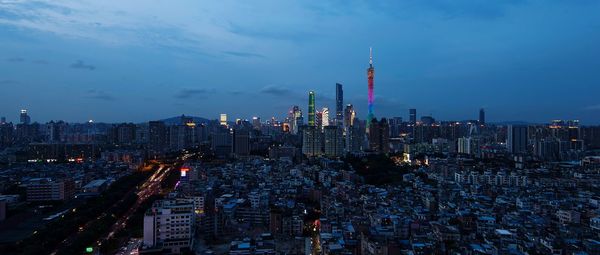 Aerial view of illuminated buildings in city against sky