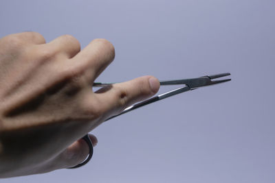 Close-up of man holding hands against white background