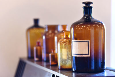 Close-up of bottles on table against wall