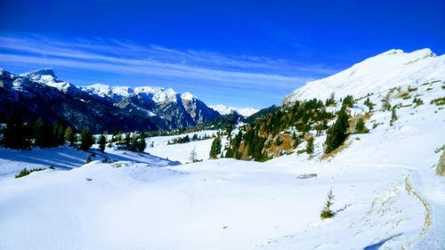 Scenic view of snow covered mountains against sky