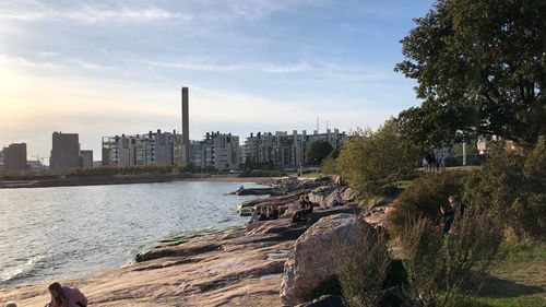 Scenic view of river by buildings in city against sky
