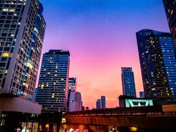 Low angle view of illuminated buildings against sky at sunset