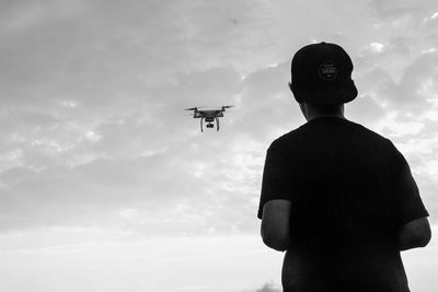 Low angle view of silhouette man standing against sky