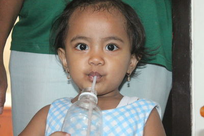 Close-up portrait of cute girl holding camera