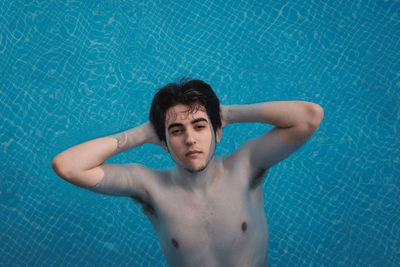 High angle portrait of young man swimming in pool