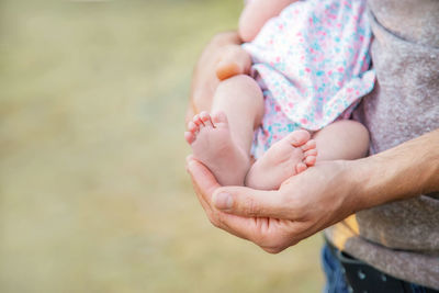 Midsection of mother holding legs of baby