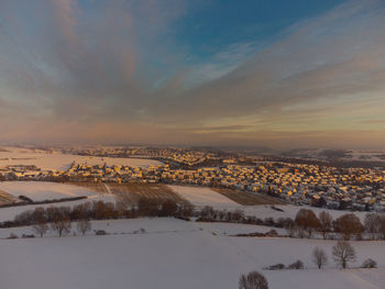 Aerial view of snowcapped landscape against sky during winter