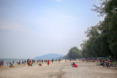 Group of people on beach against sky