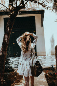 Rear view of woman standing against building