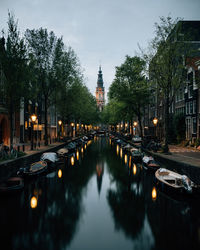 A calm evening by the river in amsterdam, netherlands, with the lights illuminating.