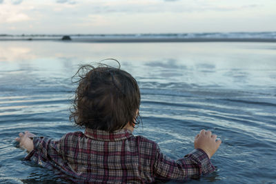 Rear view of woman looking at sea against sky