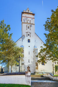 Low angle view of clock tower amidst buildings against sky