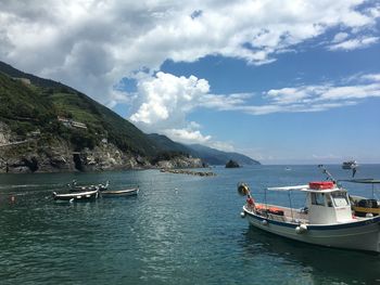 Boats moored in sea against sky