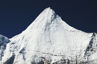 Low angle view of snowcapped mountain against clear sky