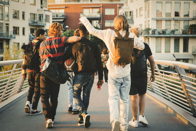 Rear view of people walking on street in city