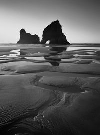 Rock formations in sea against clear sky