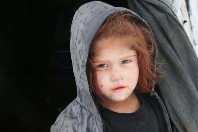 A syrian refugee child at the door of his snow covered tent