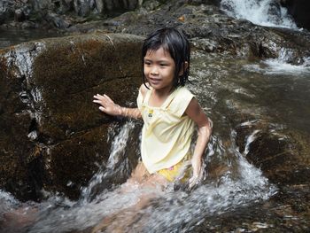 Smiling girl sitting at stream