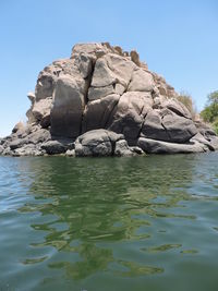 Scenic view of rocks in sea against clear sky