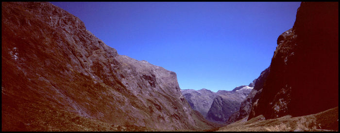 Low angle view of mountains against clear blue sky