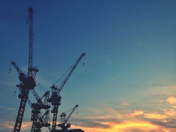 Low angle view of crane against sky during sunset