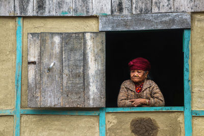 Portrait of woman standing against wall