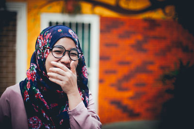 Portrait of beautiful woman standing against wall giggle laughter. 