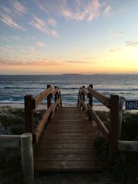 Pier over sea against sky during sunset