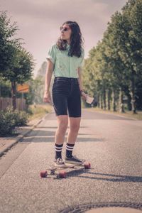 Full length of man skateboarding on road