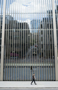 Man walking on street against modern buildings in city